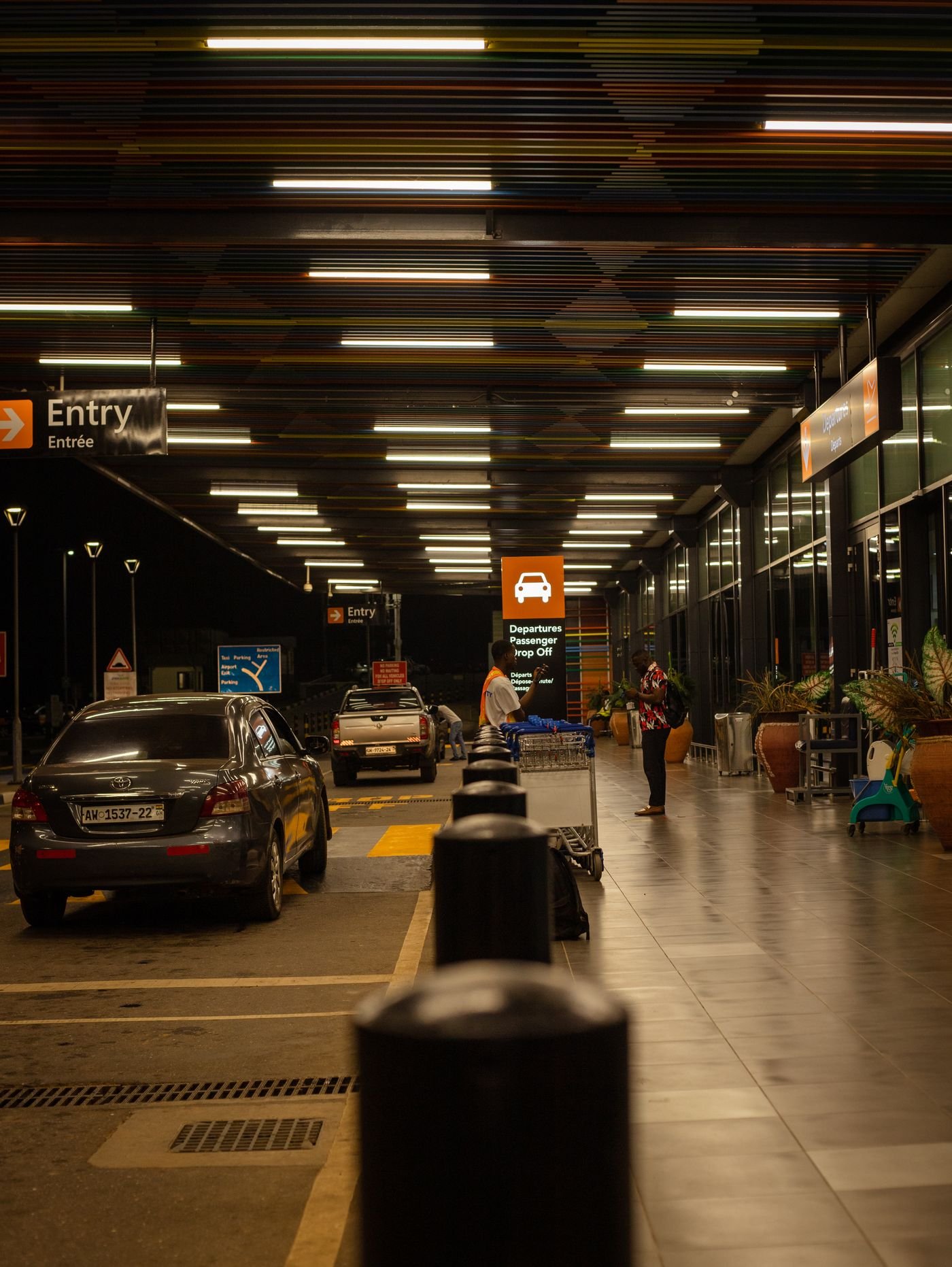 Cars at an Indian airport drop-off lane at night